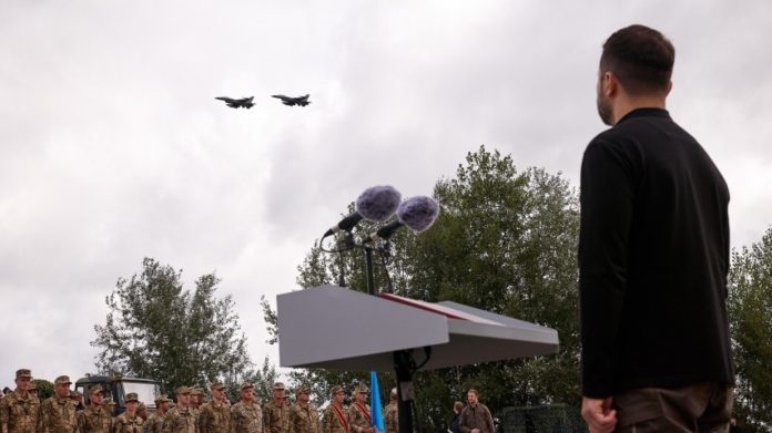 Ukrainian leader Vladimir Zelensky looks at a pair of F-16 fighter jets